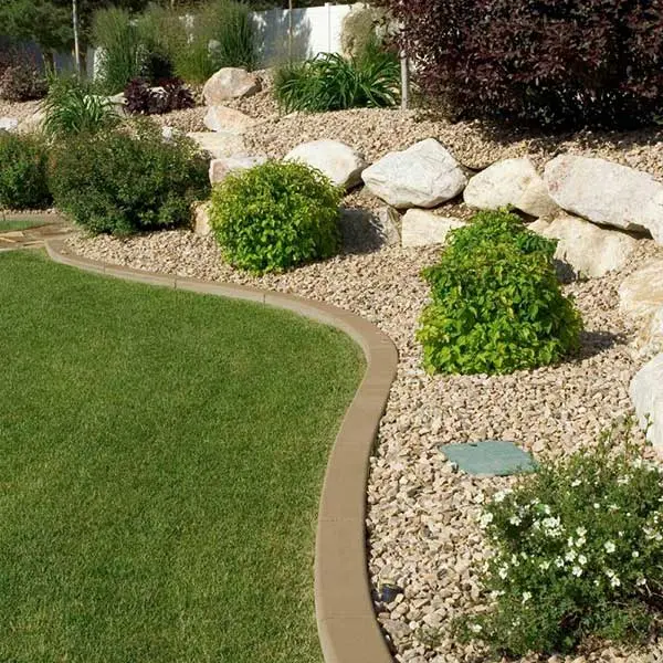 cta-landscape-maintenance A beautifully landscaped garden features green bushes surrounded by gravel and a lush lawn, bordered by stone edging. The scene showcases low maintenance landscaping with drought tolerant plants, ideal for residential landscaping in Las Vegas.| Sun Valley Landscape Las Vegas