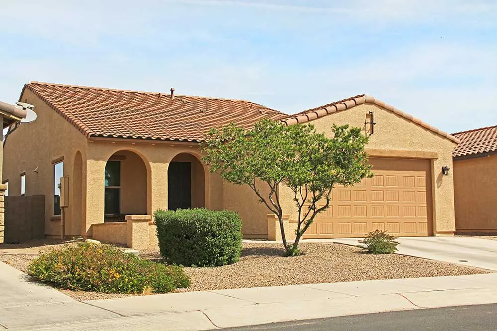 home-landscape-design Single-story home with stucco exterior and red-tiled roof features a front yard designed with desert landscaping, including native desert plants and gravel, for a low maintenance landscaping solution ideal for Las Vegas.| Sun Valley Landscape Las Vegas