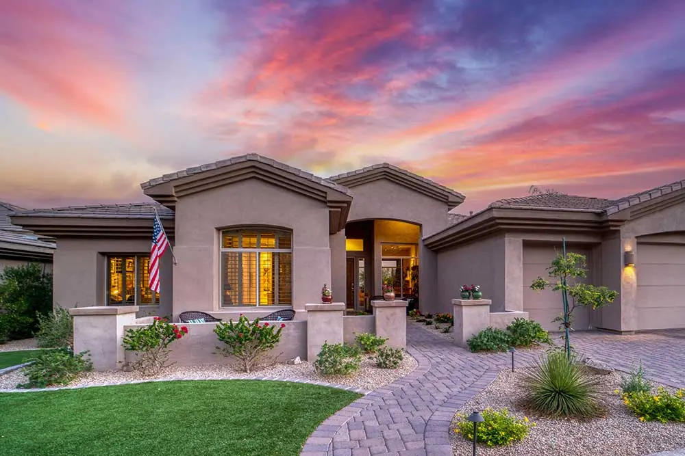 landscape-maintenance-3 A modern home at sunset with a paver patio, surrounded by lush drought tolerant plants and artificial grass, exemplifying low maintenance landscaping in a residential Las Vegas area.| Sun Valley Landscape Las Vegas