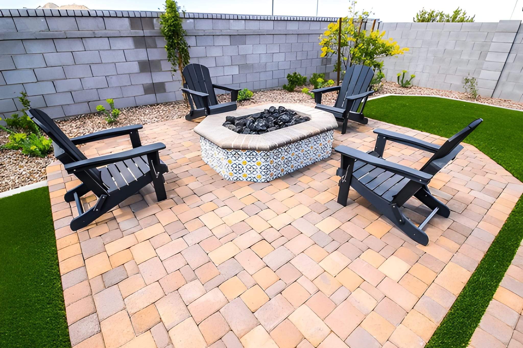 Brick paver patio with fire pit and seating area designed by Sun Valley Landscaping for Las Vegas backyard relaxation.