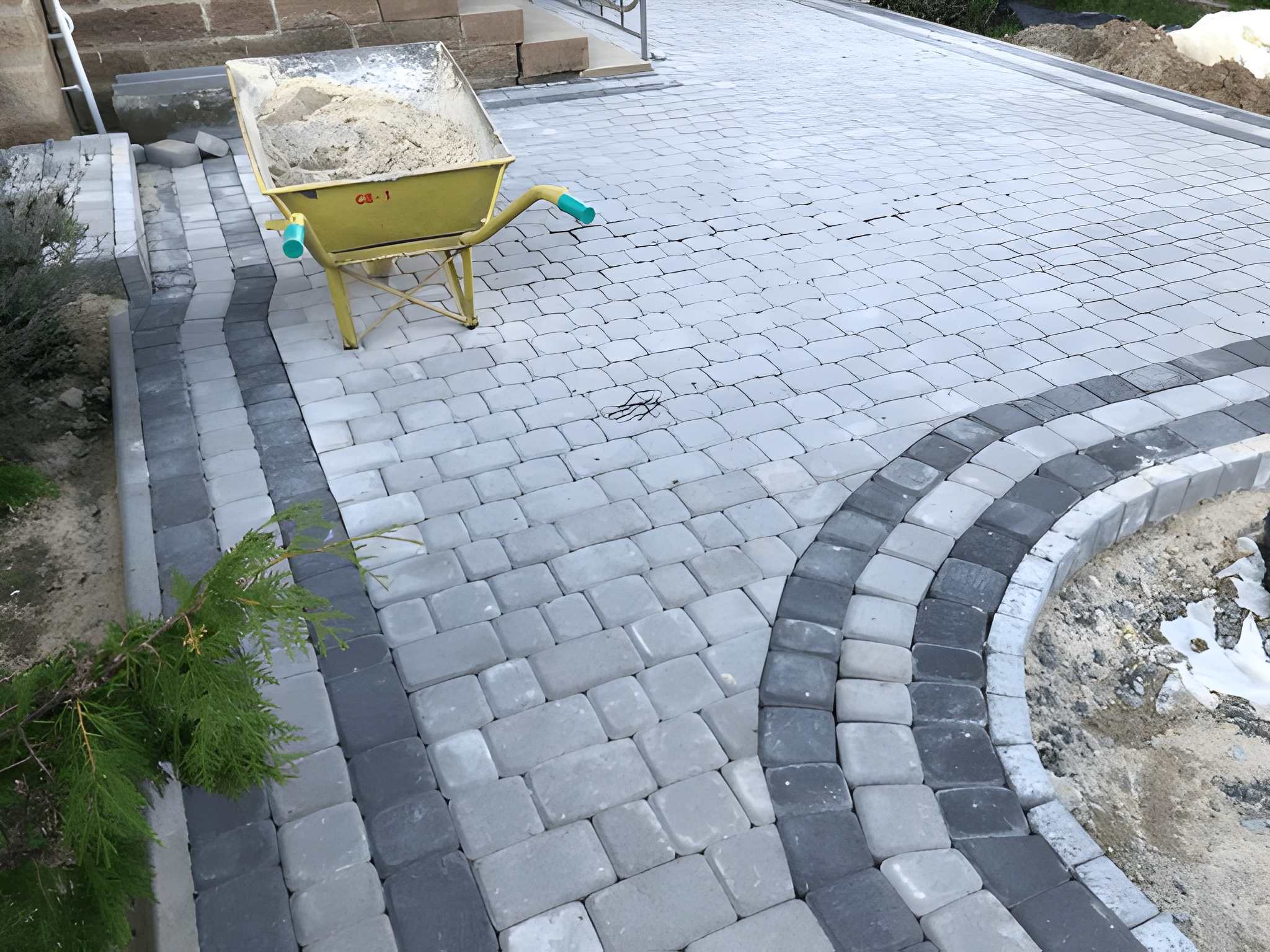 Low Maintenance Landscaping Las Vegas Ideas for the New Year-4 Sun Valley Landscaping worker sets interlocking pavers for a new driveway in a modern home’s front yard, creating a low-maintenance landscape.
